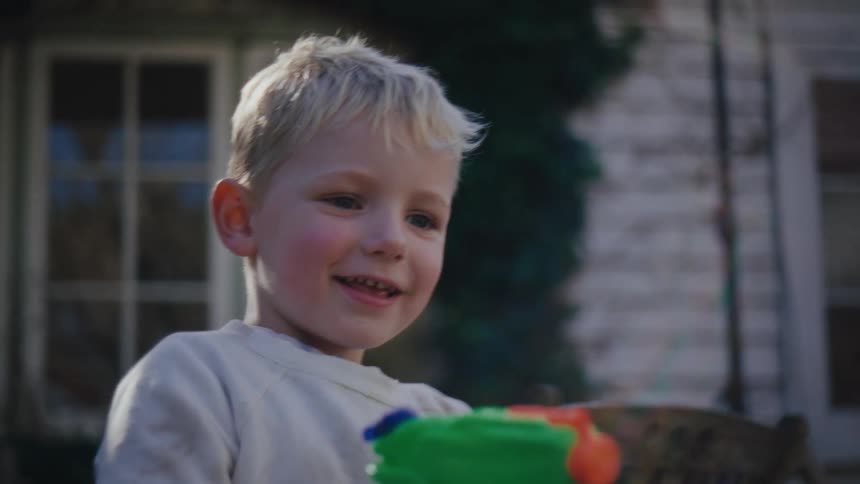 Little boy with a water gun playing