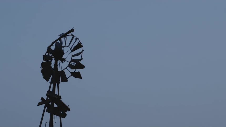 Tall wooden weather vane against a blue and purple sky