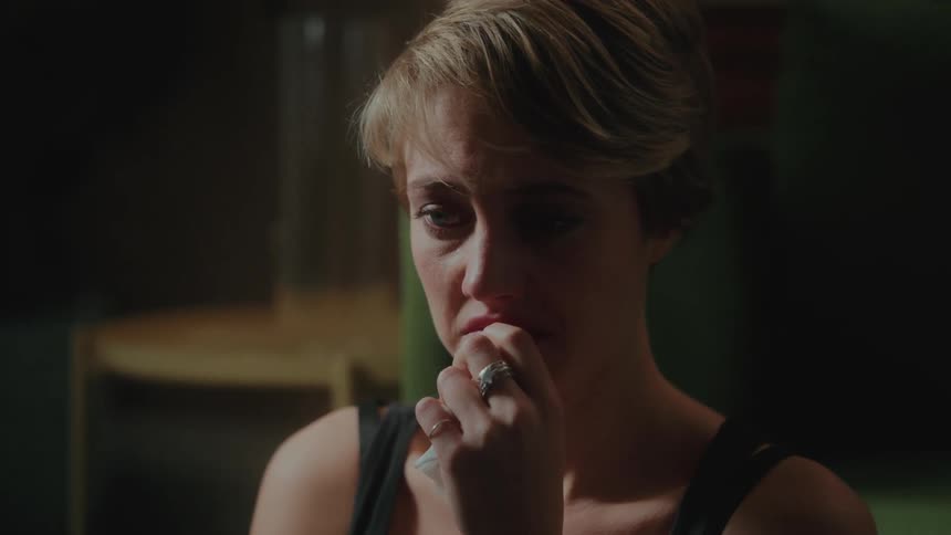 Portrait of a young blonde woman with short hair with a crying facial expression