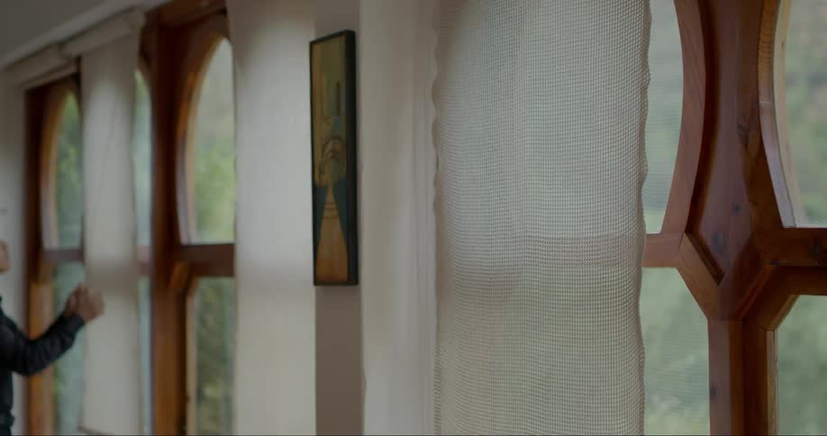 Person lifting window blinds