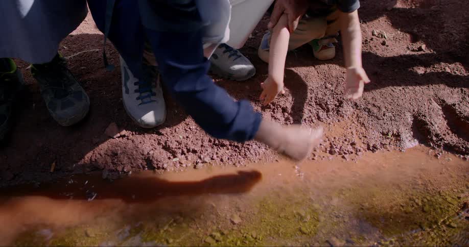 A close up clip of people washing hands from a shallow stream