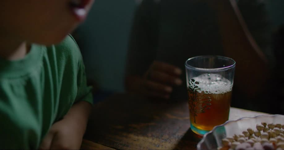 A clip of a kid eating and another person drinking