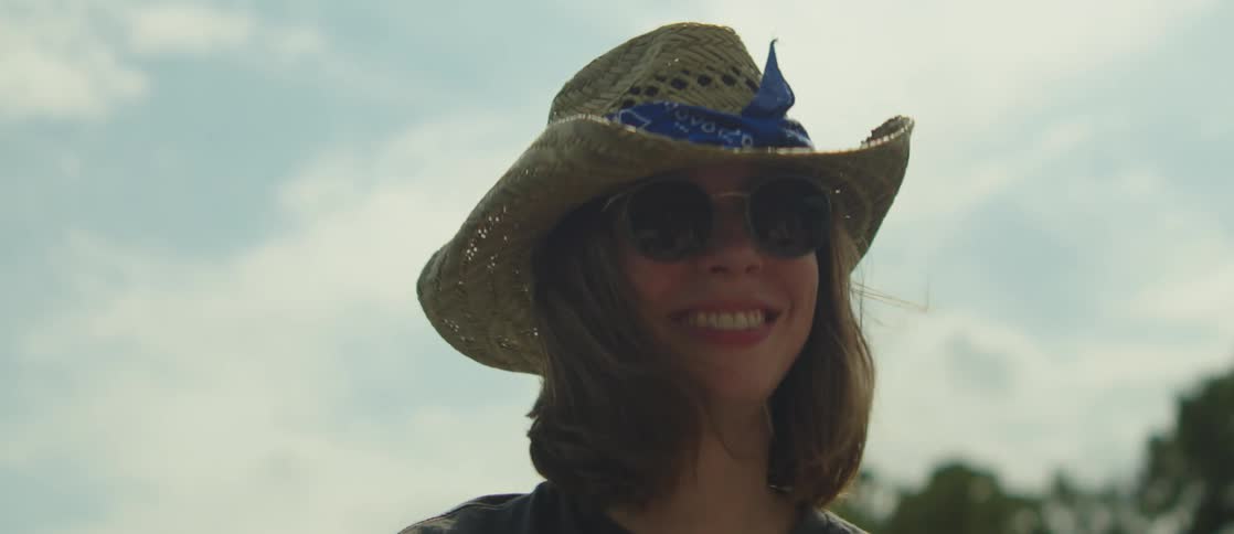 Portrait of a young woman in hat and sunglasses smiling