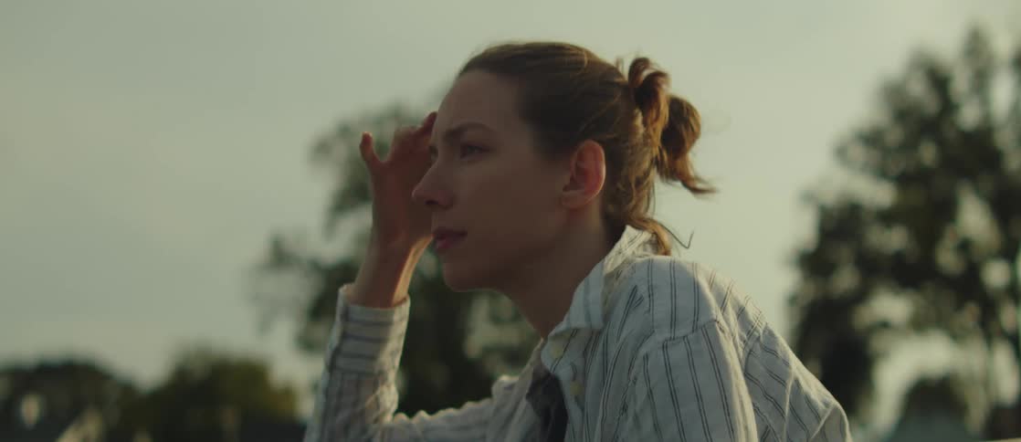A woman in nature speaks and points into the distance