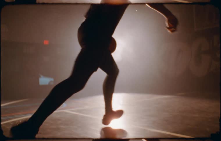A clip of a basketball player playing in the court at night