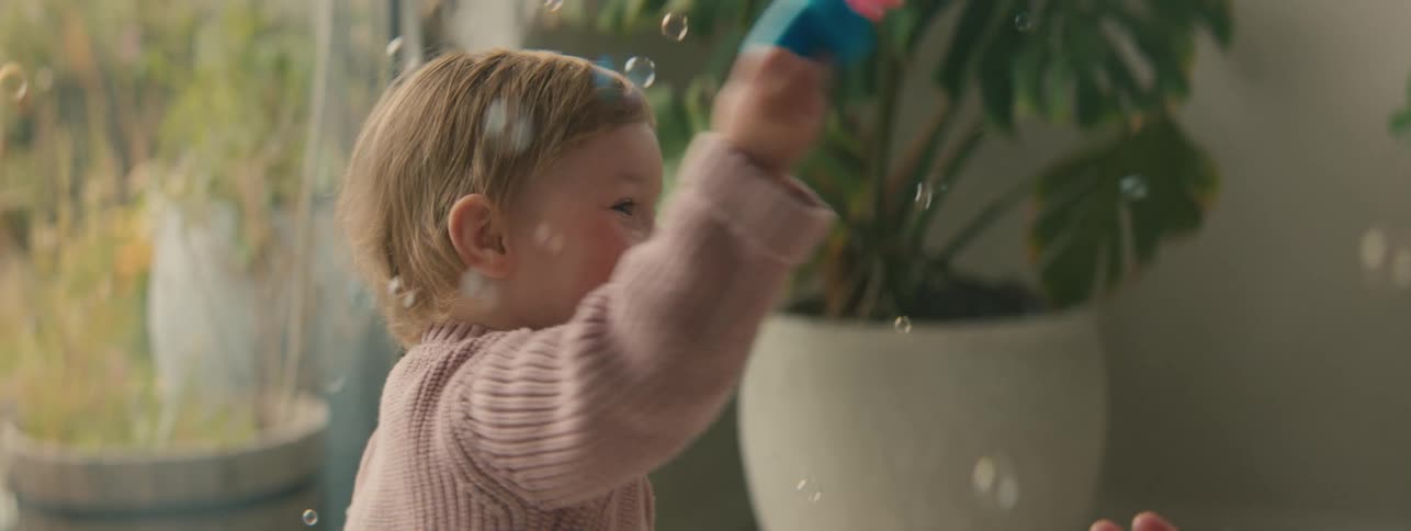 A child is blowing bubbles at home