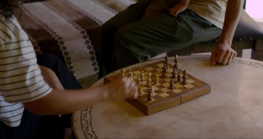 Two people sitting playing chess