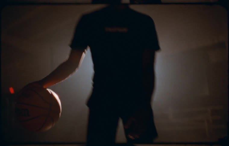 A bright radiant light source shining directly into the camera creating a lens flare effect and silhouetting a person or object partially in the foreground