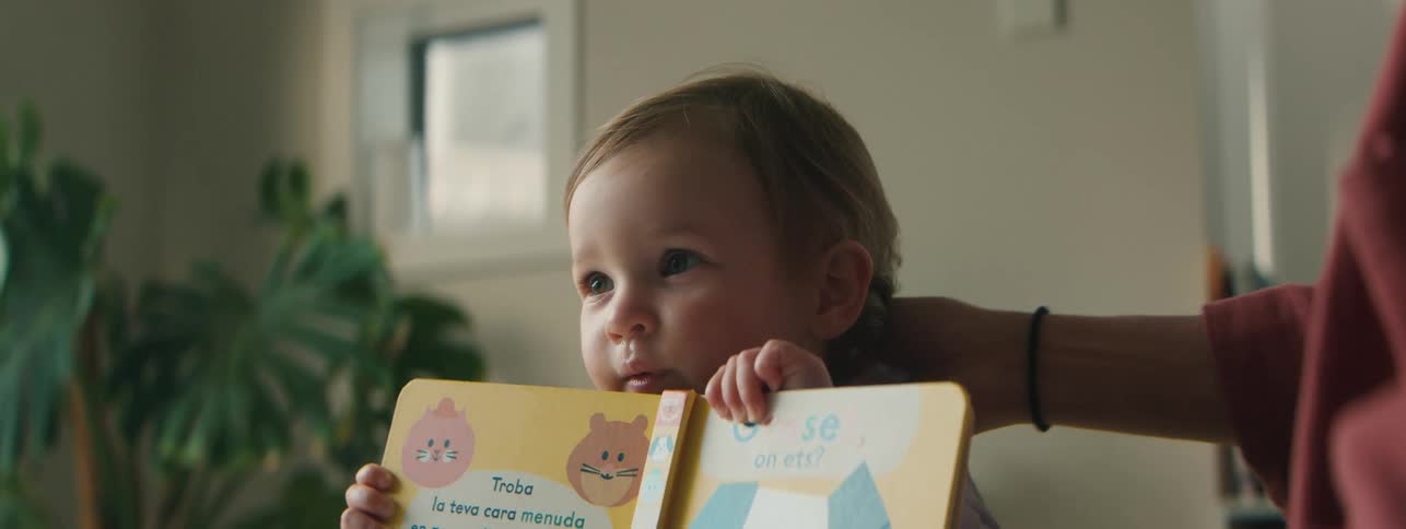 Portrait of a child playing by putting a book on his face