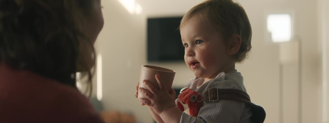 A mother plays and laughs with her son inside a home