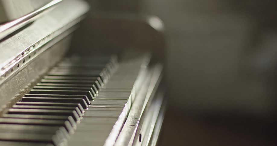 Closeup of a hand pressing a single key on a piano keyboard