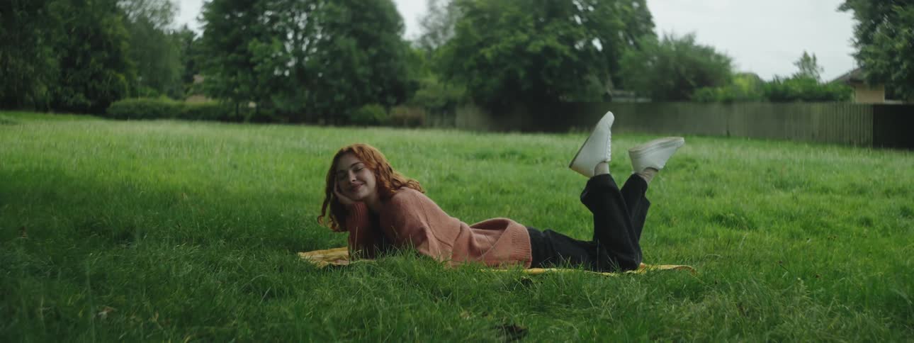 Smiling young woman lying on grass