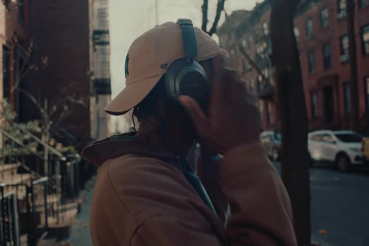 A close up clip of a black male putting on an earpiece