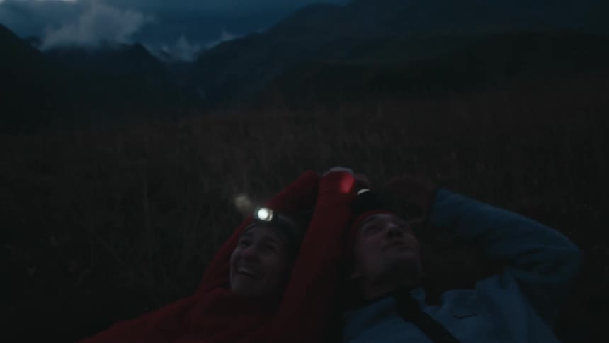 A clip of a female and a male laying on the floor out in the nature
