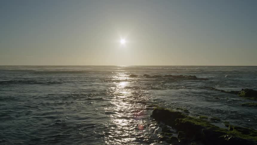 Seascape with calm waters and the sun on the horizon