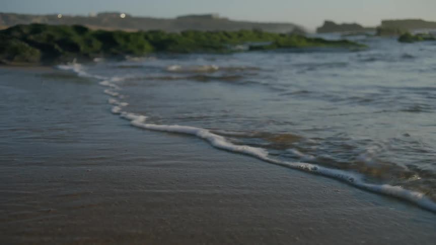 Calm waters reach the beach sand