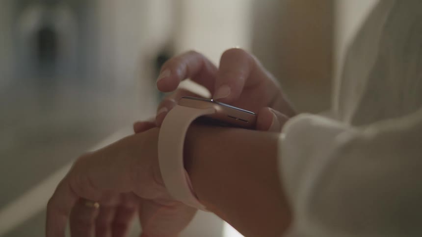 A persons hand interacting with a smartwatch on their wrist