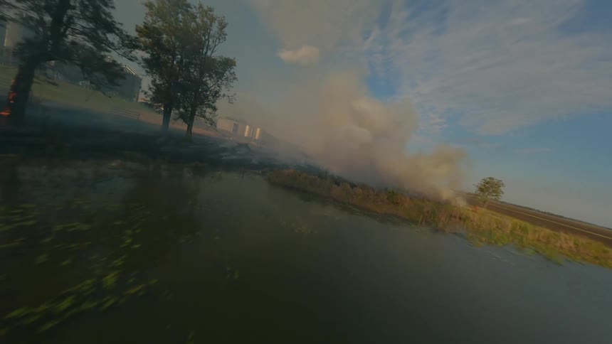 Aerial view of a field fire with smoke rising into the air