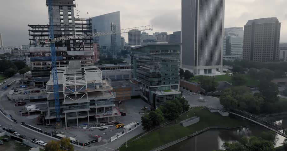 A building is being constructed near a river in a downtown city area