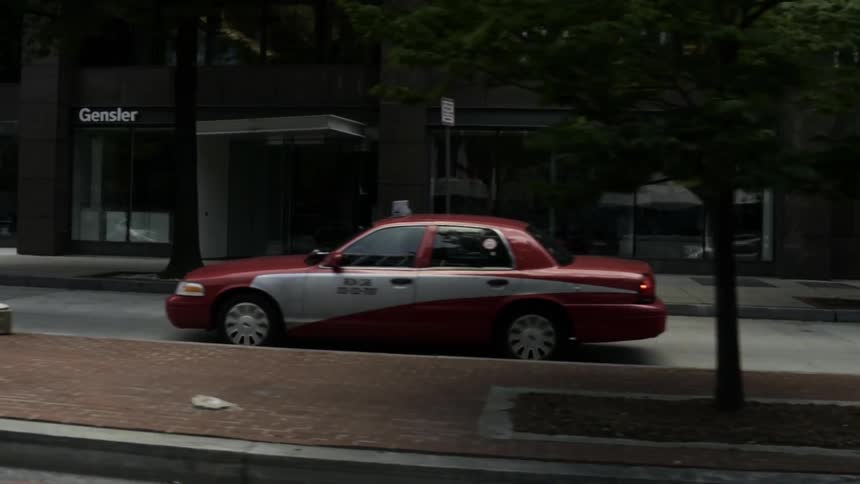 A taxi drives down a street
