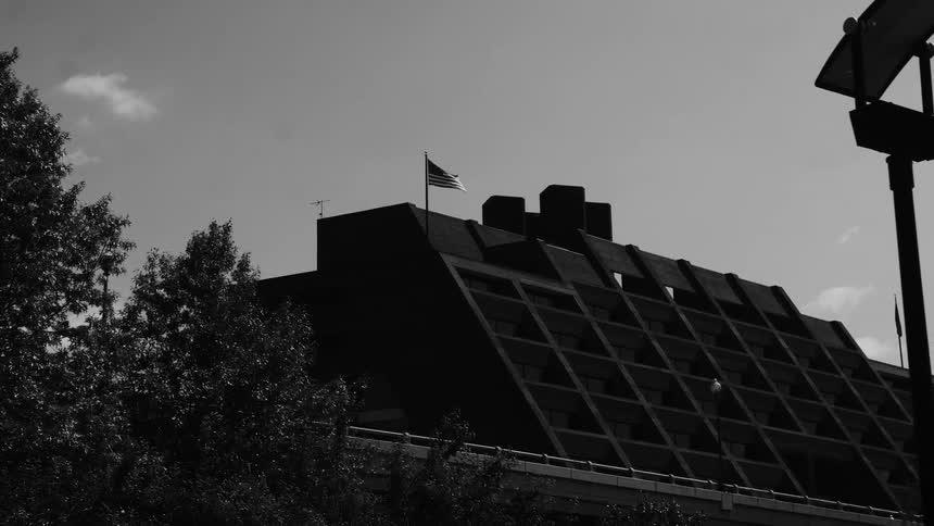 Top of a building with geometric design and flags on the roof