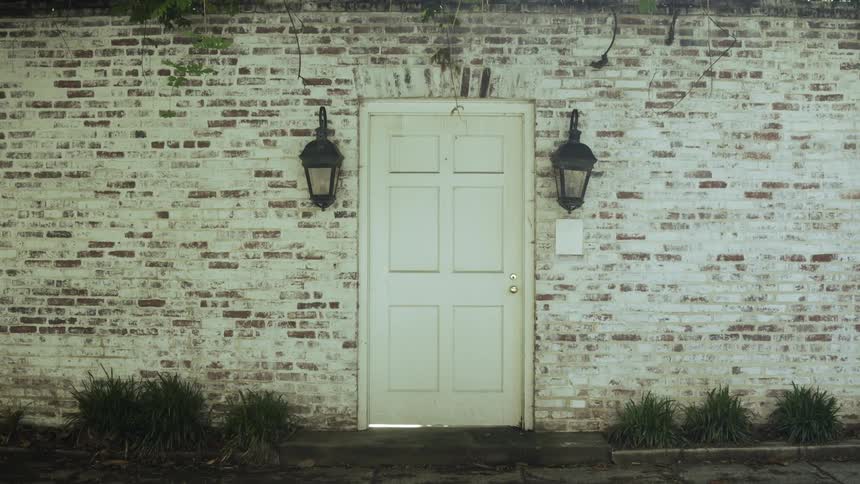A white door against an old brick wall