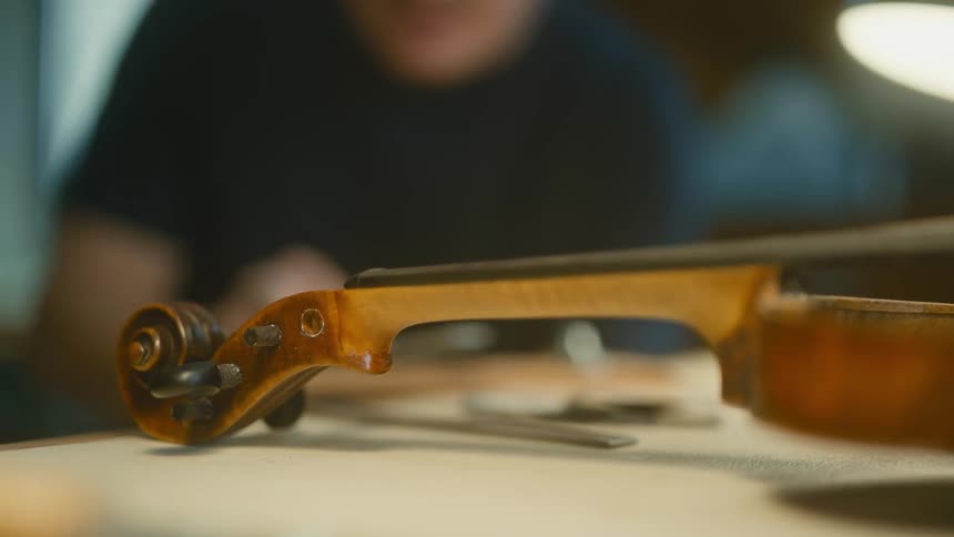 A closeup of a violin neck being worked on by a luthier