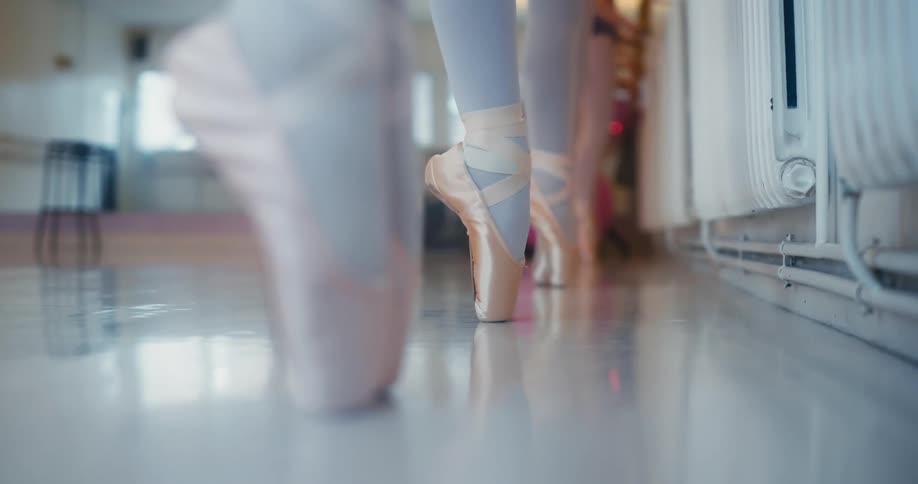 Close up of ballet dancers aligned feet