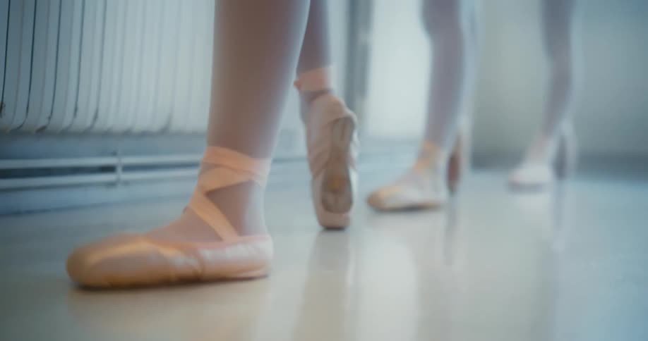 Adults hand adjusting a ballerinas foot