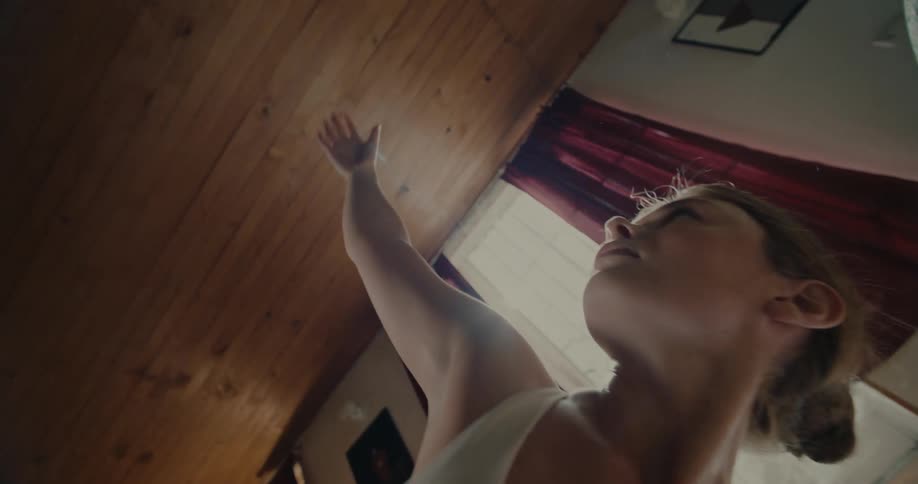 Woman indoors stretching her body on a fitness mat during the day