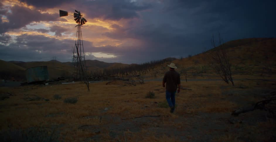 A man walks over to the windmill