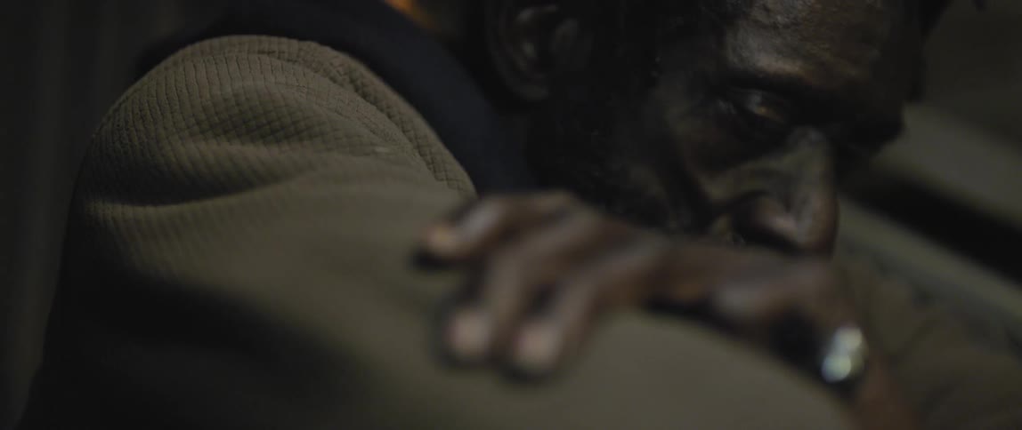 A man with his arms folded looks over