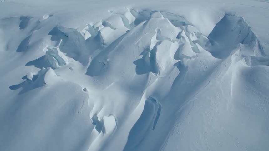 Mountains blanketed in snow in the middle of the day