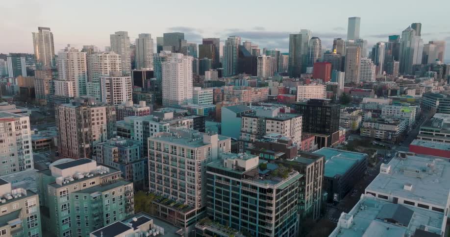 Low traverse over the dense Belltown neighborhood as soft light bathes the skyline
