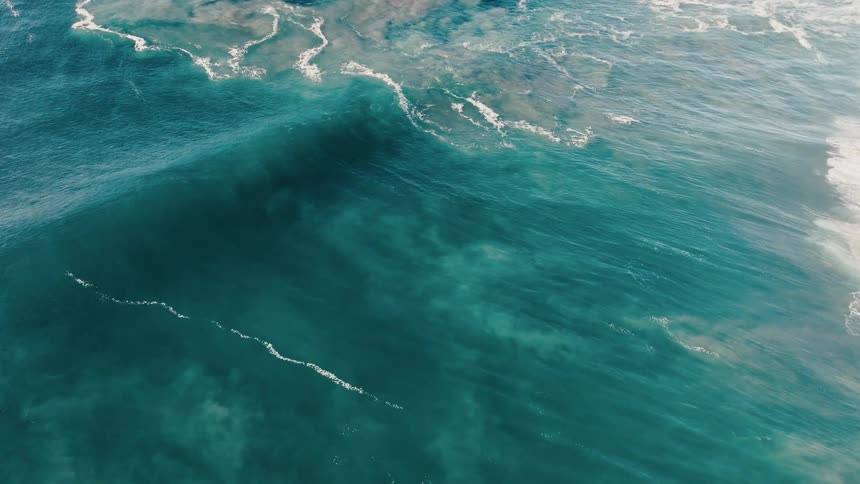 Foamy waves flow across the ocean
