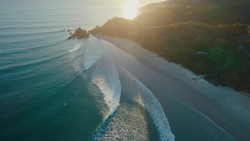 Big ocean waves wash up on a beach in a rural area