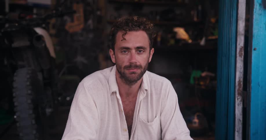 Man sits and blinks in a dilapidated room