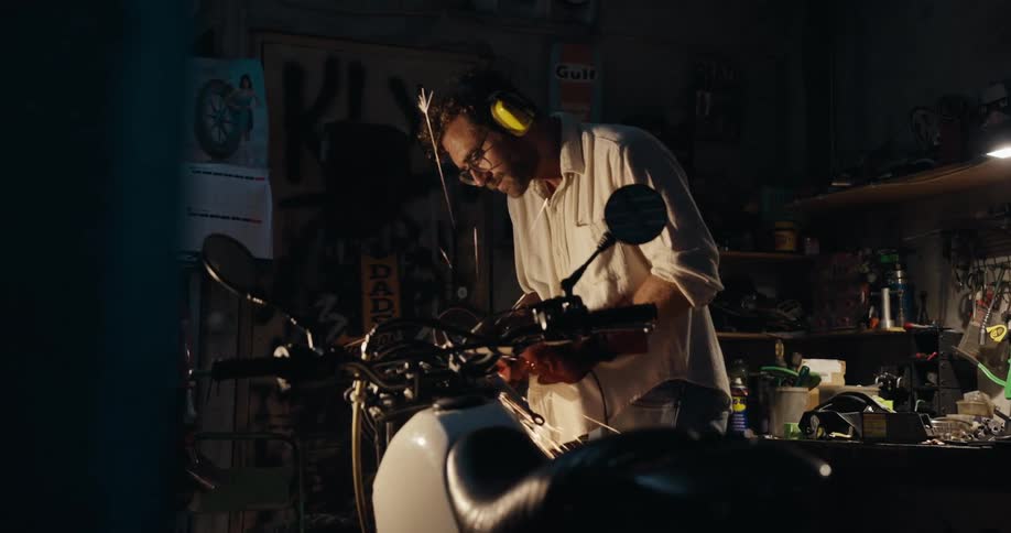 Mechanic using a tool on a motorcycle and sparks flying
