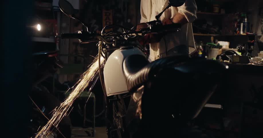 Mechanic man in a workshop working on a motorcycle