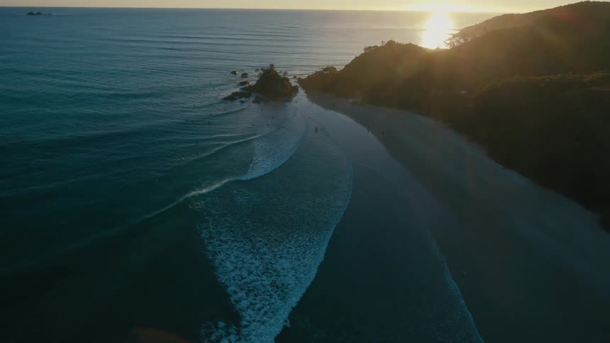 An aerial view of a serene beach with waves gently breaking against the shore