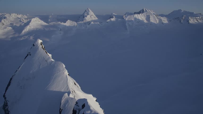 Aerial panorama of mountains with cliffs covered in snow