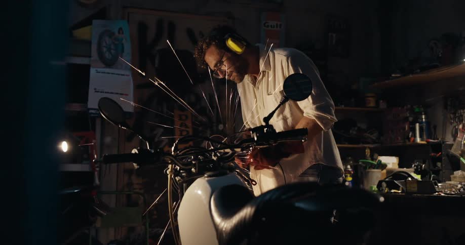 Man working on a motorcycle inside a workshop