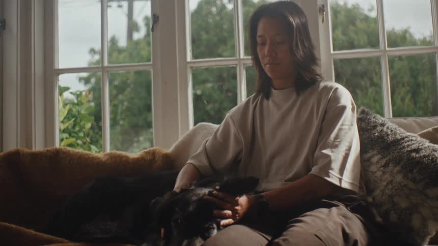 Person sitting and petting a dog