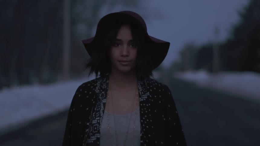 Woman walking down a road at night