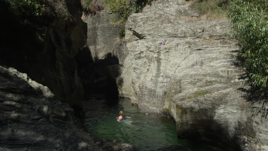 A man swims in a lake in the wilderness