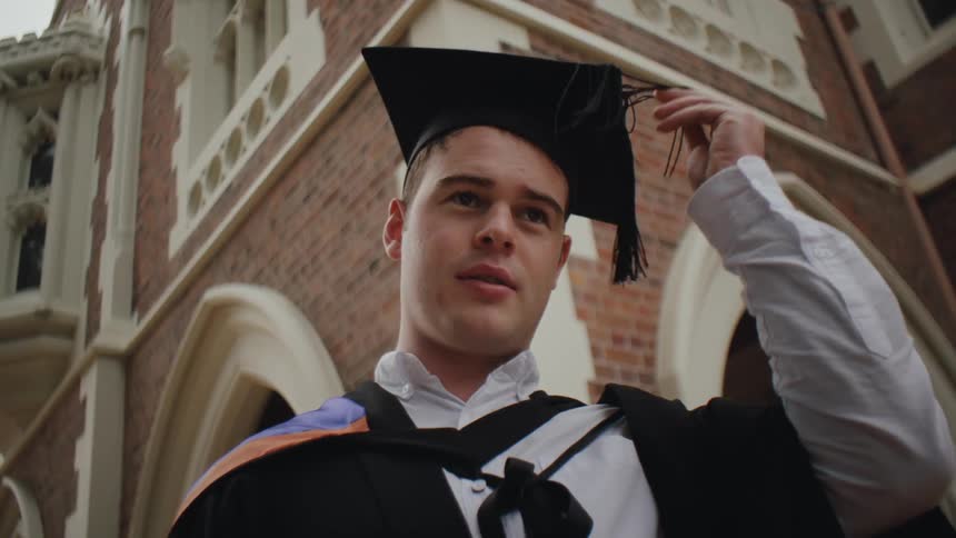 Young man adjusting his graduation cap