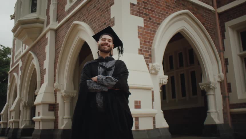 A graduate poses in his cap and gown