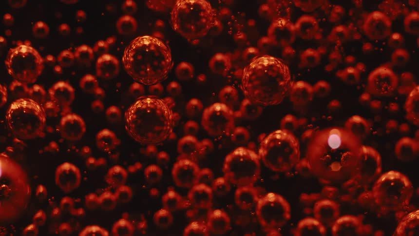 Bubbles in a red carbonated liquid popping