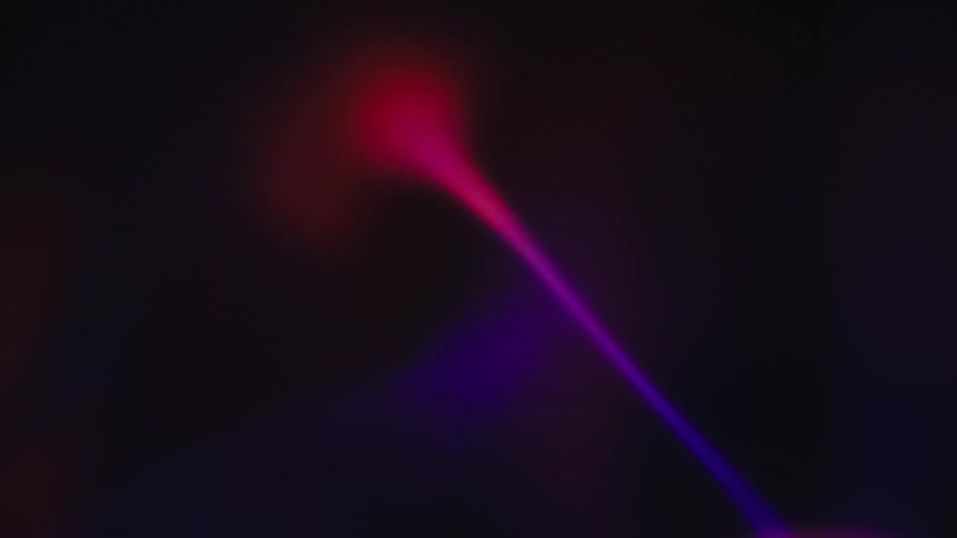 A vibrant swirling plasma of red and purple light dances across the dark background creating an otherworldly spectacle