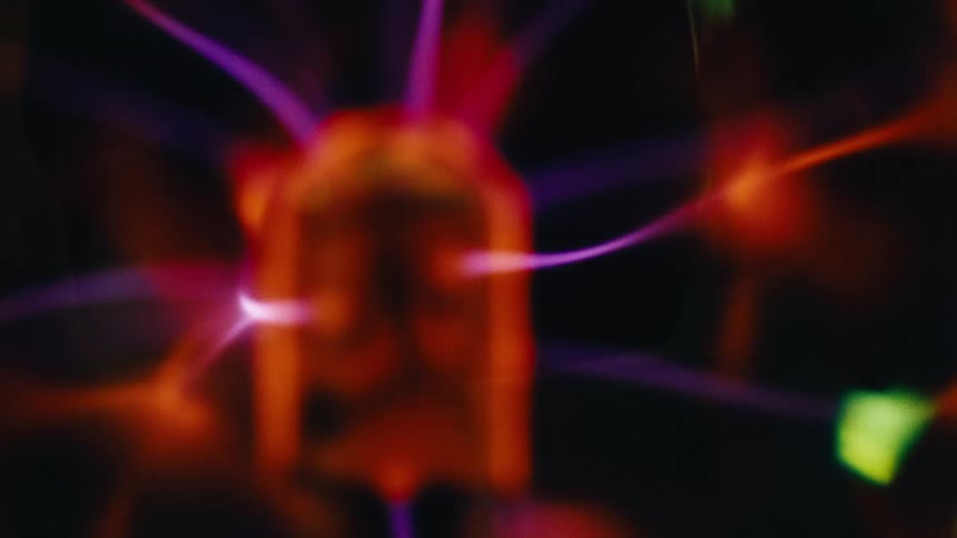 Bolts move around inside a plasma lamp in a dark area
